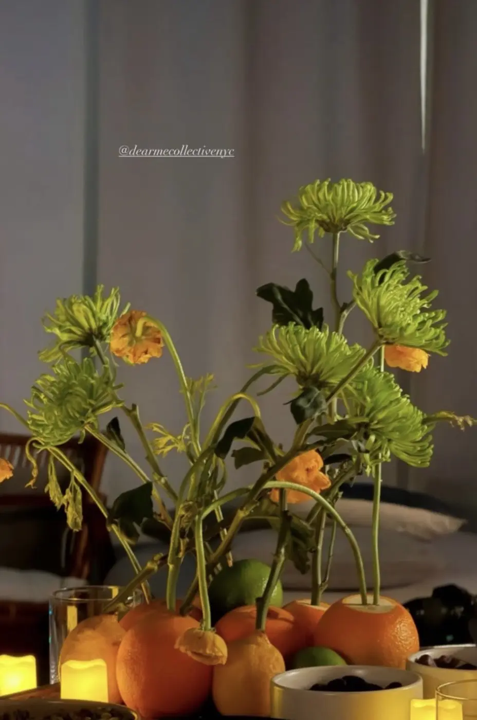 orange crown imperial and purple delphinium in a celadon vase in front of an exposed brick wall, before a cacao ceremony in a SoHo living room, New York