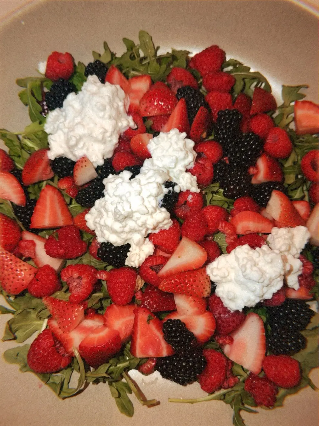 a platter of strawberries, raspberries, blackberries and whipped ricotta on rocket leaves, at a cacao ceremony in a SoHo living room, New York